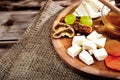 Cheese plate - various types of cheese, honey, grapes, dried apricots, nuts and figs on a wooden board. Royalty Free Stock Photo