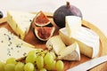 Cheese plate - various types of cheeses and figs and grapes on a Royalty Free Stock Photo