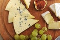 Cheese plate - various types of cheeses and figs and grapes on a Royalty Free Stock Photo