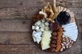 Cheese plates served with grissini, crackers, dates, jam, olives and nuts on wooden background Royalty Free Stock Photo