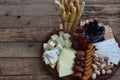 Cheese plates served with grissini, crackers, dates, jam, olives and nuts on wooden background Royalty Free Stock Photo