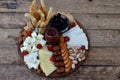 Cheese plates served with grissini, crackers, dates, jam, olives and nuts on wooden background Royalty Free Stock Photo