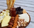 Cheese plates served with grissini, crackers, dates, jam, olives and nuts on wooden background. Cheese board. Snack to wine Royalty Free Stock Photo