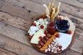 Cheese plates served with grissini, crackers, dates, jam, olives and nuts on wooden background. Cheese board. Snack to wine Royalty Free Stock Photo