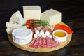 Cheese platte with different cheeses, meats on wooden board