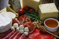 Cheese platte with different cheeses, meats on wooden board