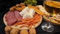 Cheese platter with assorted cheeses, grapes, nuts over black background Royalty Free Stock Photo