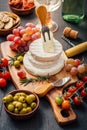 Cheese platter with brie, Camembert, grapes, olives and tomatoes