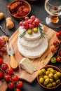 Cheese platter with brie, Camembert, grapes, olives and tomatoes