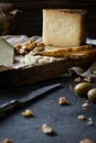 Cheese platter of chopped Spanish hard cheese manchego and sliced Italian pecorino toscano on wooden board with walnuts Royalty Free Stock Photo