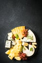 Cheese platter with craft cheese assortment at black background. Royalty Free Stock Photo