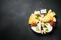 Cheese platter with craft cheese assortment at black background. Royalty Free Stock Photo