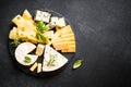 Cheese platter with craft cheese assortment at black background. Royalty Free Stock Photo