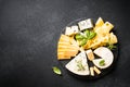 Cheese platter with craft cheese assortment at black background. Royalty Free Stock Photo