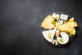 Cheese platter with craft cheese assortment at black background. Royalty Free Stock Photo