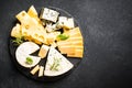 Cheese platter with craft cheese assortment at black background. Royalty Free Stock Photo