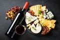 Cheese platter with craft cheese assortment on slate board at black background. Royalty Free Stock Photo