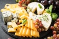 Cheese platter with craft cheese assortment on slate board.