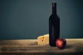 Cheese platter garnished with honey, apple and bottle of wine on rustic wooden board Royalty Free Stock Photo