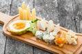 Cheese platter garnished with pear, honey, carambola, physalis on cutting board on wooden background. Snacks and Wine appetizers