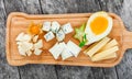 Cheese platter garnished with pear, honey, walnuts, grapes, carambola, physalis on cutting board on wooden background Royalty Free Stock Photo