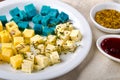 Cheese platter, Gouda, feta, blue pesto cheeses on white plate with herbs, olive oil, pomegranate and mustard sauces Royalty Free Stock Photo