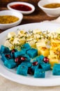 Cheese platter, Gouda, feta, blue pesto cheeses on white plate with herbs, olive oil, pomegranate and mustard sauces Royalty Free Stock Photo