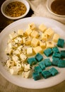 Cheese platter, Gouda, feta, blue pesto cheeses on white plate with herbs, olive oil, pomegranate and mustard sauces Royalty Free Stock Photo