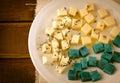 Cheese platter, Gouda, feta, blue pesto cheeses on white plate with herbs, olive oil, pomegranate and mustard sauces Royalty Free Stock Photo