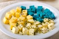 Cheese platter, Gouda, feta, blue pesto cheeses on white plate with herbs, olive oil, pomegranate and mustard sauces Royalty Free Stock Photo