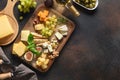 Cheese platter with grapes, nuts, figs on brown background. Top view. Copy space Royalty Free Stock Photo