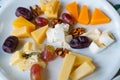 cheese platter with nuts, grapes and dates. delicious snacks with wine.