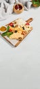 Cheese platter with nuts, honey sauce and olives on wood board. Cheeseboard on white concrete background. Cheese assorted in