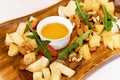 cheese platters, nuts, honey, strawberries and arugula on a wooden tray.