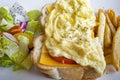 Cheese scram bled egg, white bread loaf, mixed greens and french fries Royalty Free Stock Photo