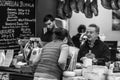 Cheese seller serving customer at the Borough Market, London, UK, grayscale