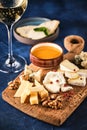 Cheese set with honey and nuts. Assortment of cheeses on a wooden board. Cheese appetizer set