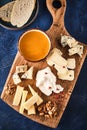 Cheese set with honey and nuts. Assortment of cheeses on a wooden board. Cheese appetizer set