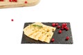 Cheese slices, rosemary and cranberries on a black stone kitchen board. Isolate on a white background Royalty Free Stock Photo