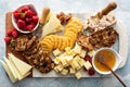 Cheese and snacks board with raspberry and crackers Royalty Free Stock Photo