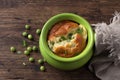 Cheese souffle with young peas flavored with thyme in portion molds on a wooden table