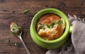 Cheese souffle with young peas flavored with thyme in portion molds on a wooden table