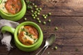 Cheese souffle with young peas flavored with thyme in portion molds on a wooden table