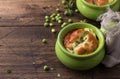 Cheese souffle with young peas flavored with thyme in portion molds on a wooden table