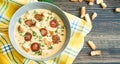 Cheese soup with grilled sausages and herbs. Cream soup served in a plate. Dark wooden background. Space for text Royalty Free Stock Photo