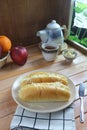 cheese-stuffed bread served on a white plate with apples and a teapot in the background Royalty Free Stock Photo