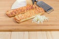 Cheese-stuffed bread sticks, different cheese on wooden cutting board