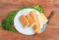 Cheese-stuffed flaky pastry sticks, various cheese, greens, knife