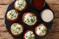 Cheese stuffed mushrooms wrapped in bacon served with sauces close-up on a plate. horizontal top view Royalty Free Stock Photo