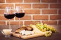 Cheese, toasted brown bread, two glasses of red wine. Royalty Free Stock Photo